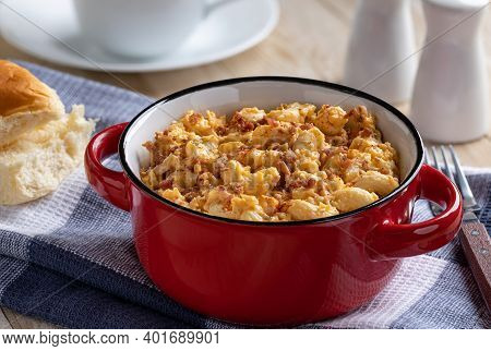 Closeup Of A Bowl Of Macaroni And Cheese With Bacon Pieces On Wooden Table