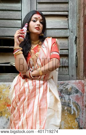 Portrait Of Beautiful Indian Woman Wearing Traditional Indian Saree, Gold Jewellery And Bangles Hold