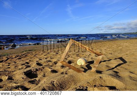 Wooden Photo Frame, Sea Shell On The Sand At Dawn. Sea Surf Background