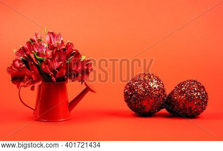 Mini Watering Can With Flowers On A Red Background And Shiny Apple On A Red Background. Copy Space, 