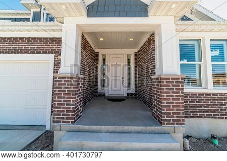Home Entrance With Portico And White Front Door Flanked By Narrow Sidelights