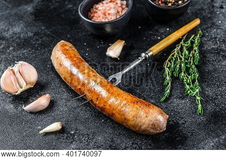 Pork Sausage Bbg Grilled With And Herbs On A Meat Fork. Top View. Black Background
