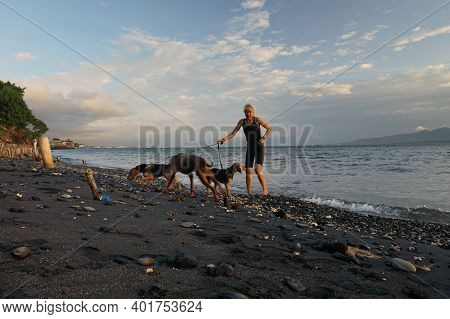 Banyuwangi, Indonesia - May 14, 2020 : A Woman Playing With The Dogs At Watudodol Beach Banyuwangi I