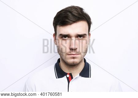 Portrait of young bearded sportsman looking into camera with disappointment and despair expression on his face. Close up of strong unhappy man with brown hair.