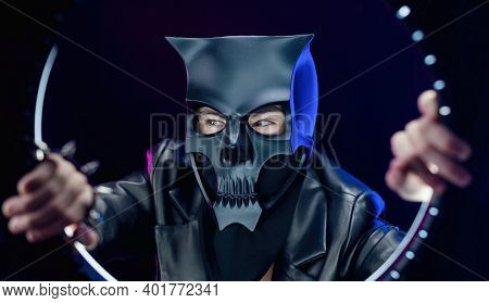 A Man Wearing A Demon Skull Mask In A Leather Cloak