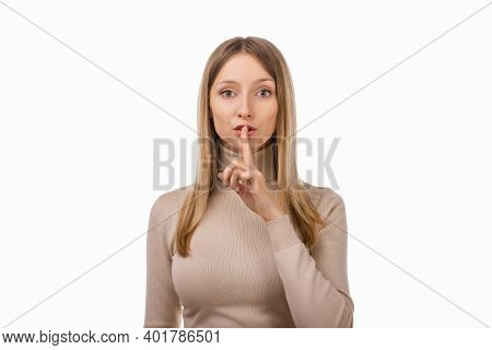 Portrait Of Young Blond Woman Keeping Finger At Her Mouth, Saying Shh, Hush, Tsss. Silence And Secre