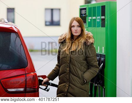Young Caucasian Woman At Self-service Gas Station, Hold Fuel Nozzle And Refuel The Car With Petrol, 
