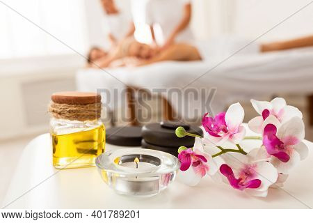 Couples Massage Spa Composition With Stones, Bottle Of Body Oil, Candle And Orchid Flowers Lying On 