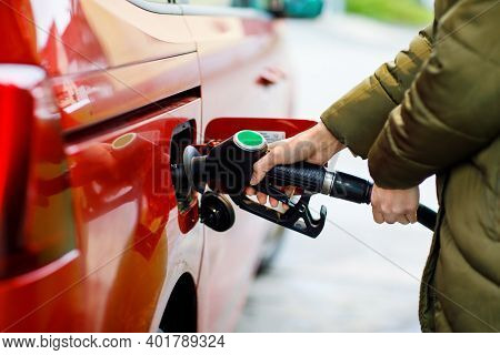 Close-up Of Hands Of Woman At Self-service Gas Station, Hold Fuel Nozzle And Refuel The Car With Pet
