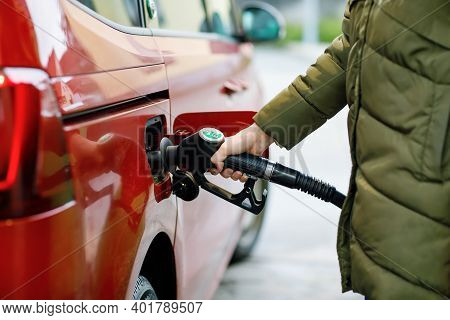 Close-up Of Hands Of Woman At Self-service Gas Station, Hold Fuel Nozzle And Refuel The Car With Pet