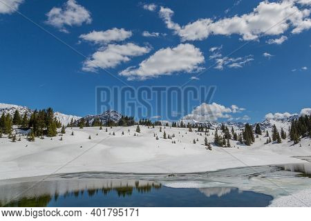 Snowy Spring Landscape Near Arosa With Lake Lower Praetsch, Cloudy Blue Sky