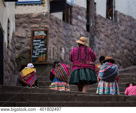 Indigenous Quechua Women In Traditional Colorful Handwoven Textile Clothing Dress Costume Walking In