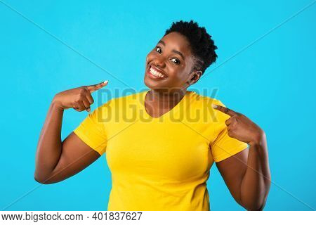 Self-confidence. Happy Plus-size Black Woman Pointing Fingers At Herself Posing Standing Over Blue S