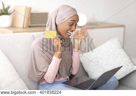 Excited Black Arab Woman In Hijab With Credit Card Happy Over Unexpected Win Or Grand Sale In Online