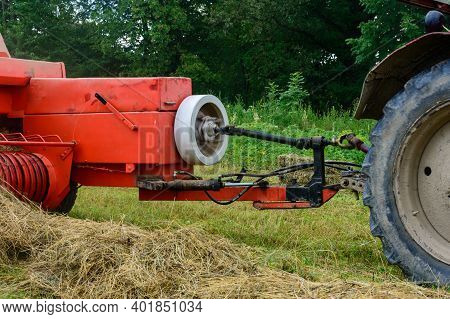 Tractor And Cardan Shaft For Coupling Equipment, Tractor In The Field During Haymaking.