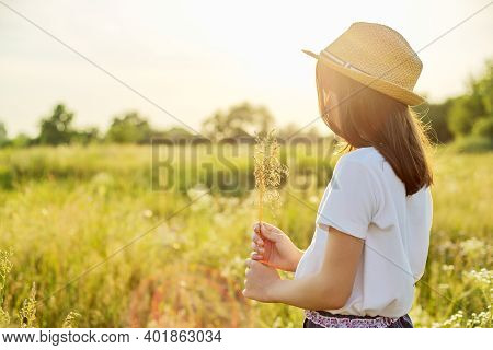 Summer Nature, Back View Of Child Girl In Straw Hat Tearing Meadow Grasses, Copi Space Beautiful Sun