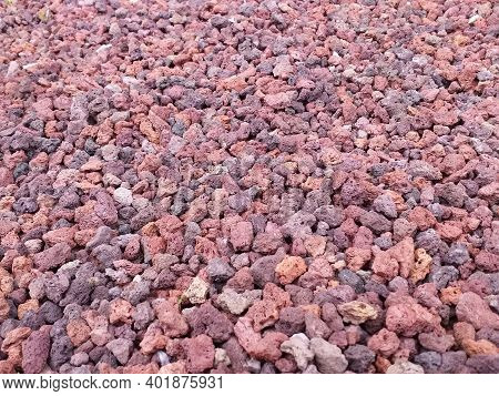 Reddish Volcanic Gravel Background. Red Volcanic Stone, Porous In Appearance, Of Different Shapes An