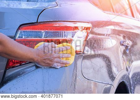 Close Up Man's Hand Using Sponge And Foam To Washing Taillight Modern Car In Perspective Side View