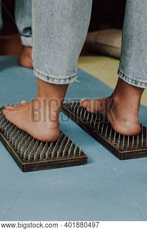 Group Practice Of Standing On Nails. Closeup Of Yoga Person Standing On Sadhu Board With Sharp Nails
