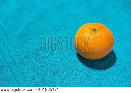 Summer Fruit Concept With Fresh Bright Orange Or Manderin On Cyan Blue Beach Towel. Minimal High Con