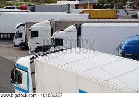Resting Place. Various Types Of Trucks In The Parking Lot Next To The Motorway.