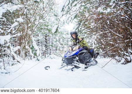Man On Snowmobile In Winter Mountain. Snowmobile Driving. Man Driving Snowmobile In Snowy Forest