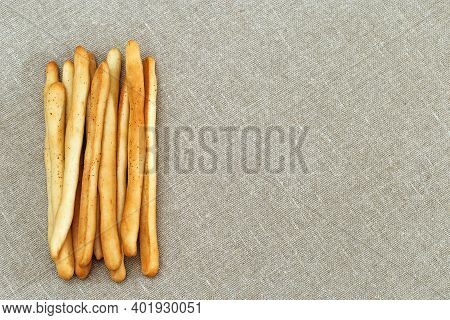 Heap Of Fresh Grissini Are Crispy Bread From Italian Cuisine. Top View On Breadsticks Lie On Linen C