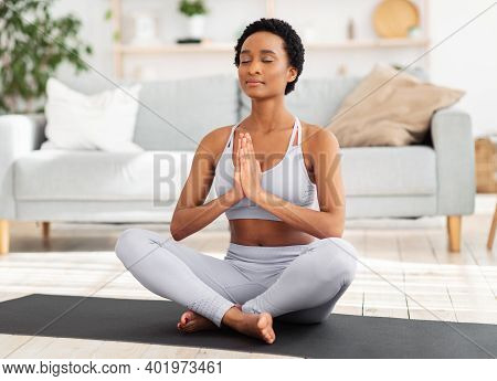 Reaching Inner Peace And Harmony. Positive Black Woman Meditating With Closed Eyes, Doing Breathing 