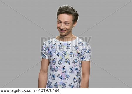 Portrait Of Shy Teen Boy On Gray Background. Attractive Teenage Guy Loooking At Camera. Kids Innocen