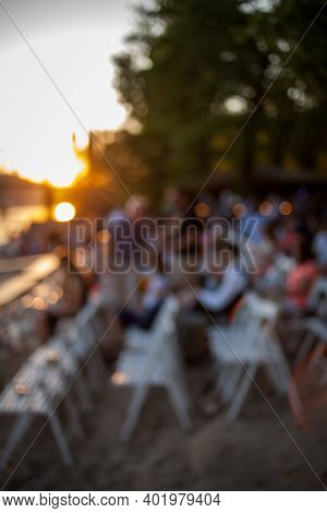 People Are Watching A Concert Of Classical Music. Blurred Young And Adult Women And Men And Other Pe