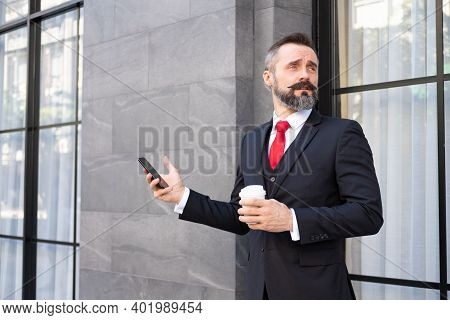 Selective Focus At Face. Adult Caucasian Business Man With Beard, Dress In Formal Suit Standing In C