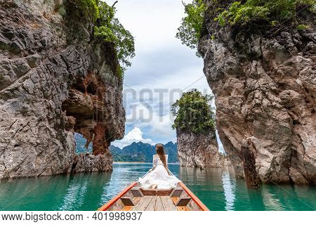 Back View Of Young Female Tourist In Dress And Hat At Longtail Boat Near Famous Three Rocks With Lim