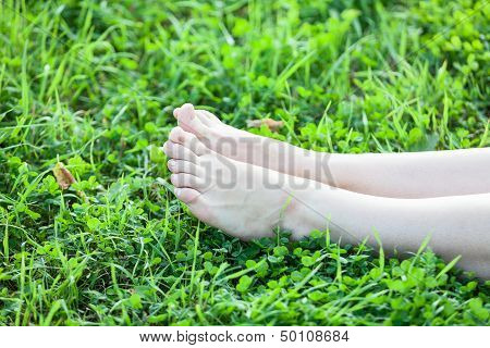 Barefooted Attractive Female Legs Laying In Green Grass