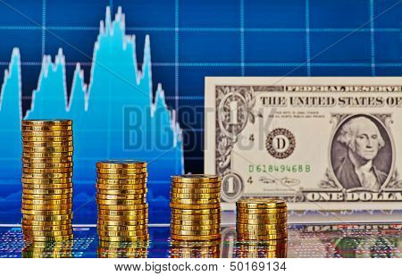 Downtrend Financial Chart, One-dollar Banknote And Stacks Of Golden Coins. Selective Focus