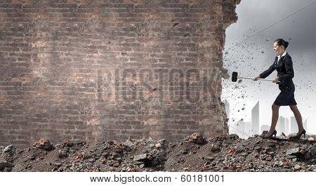 Young attractive businesswoman with hammer in hands
