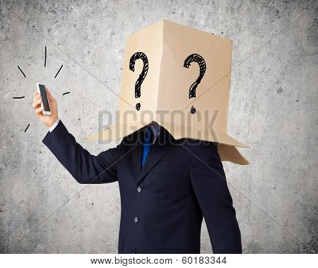 Businessman using mobile phone wearing carton box on head