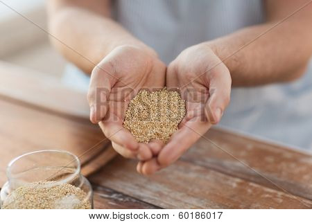 cooking and home concept - cloes up of male cupped hands with quinoa