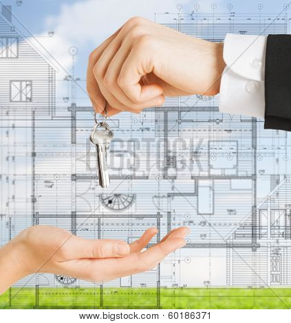 real estate, constructure, architecture and develooing concept - close up of man hand passing house keys to woman