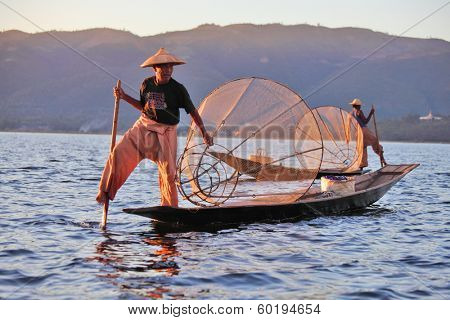 INLE LAKE, MYANMAR ÃÂ¢Ã?Ã? DECEMBER 12, 2013: Fishermen at Inle Lake, Shan State, Myanmar Intha people possess the leg-rowing style and the unique coop-like fishing equipment 