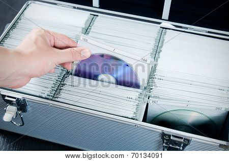 Hand Pulls Disc From Aluminum Carrying Cd-dvd Case