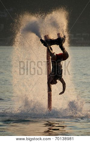Flyboarder Diving Amid Spray After Back Flip
