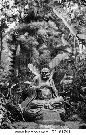 Old ruined Arhat Kanakbharadvaja statue in forest, Taiwan, Asia.