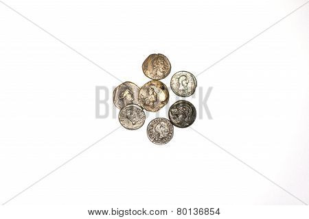 Seven Ancient Coins On A White Background