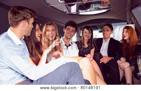 Happy friends chatting in limousine on a night out