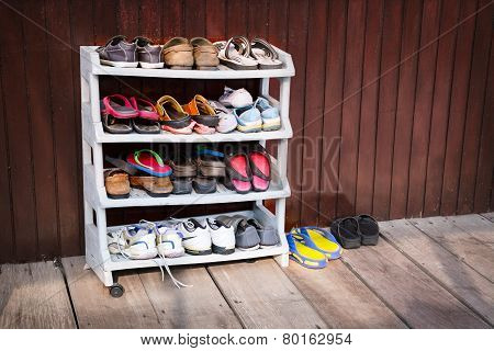 Colorful Shoes On A Plastic Shoe Rack Outside A House