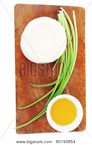 dairy products : feta white cheese on cut board with olive oil in small saucer isolated over white background