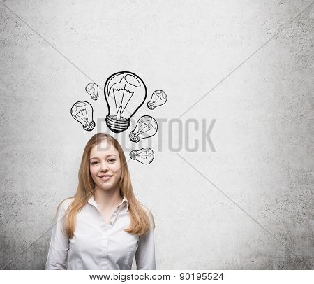 Smiling Young Beautiful Business Lady Is Thinking About New Innovative Ideas. Light Bulbs Are Drawn