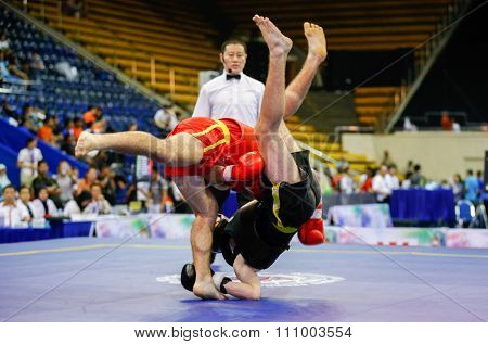 JAKARTA, INDONESIA - NOVEMBER 15, 2015: Alessandro Cutuli of Italy (red) fights Aleksandr Yudin of Ukraine (black) in the men's 70kg Sanda event at the 13th World Wushu Championship 2015.