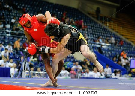 JAKARTA, INDONESIA - NOVEMBER 15, 2015: Ishan Naligamage of Sri Lanka (red) fights Saipiev Ilgizbek of Kazakhstan (black) in the men's 70kg Sanda event at the 13th World Wushu Championship 2015.