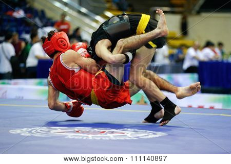 JAKARTA, INDONESIA - NOVEMBER 16, 2015: Ali Magomedov of Russia (red) fights Aliaksei Kaziuchyts of Belarus (black) in the men's 60kg Sanda event at the 13th World Wushu Championship 2015.